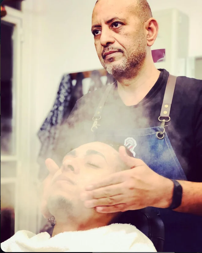 Abdul realizando un cuidado de barba con vapor en su barbería
