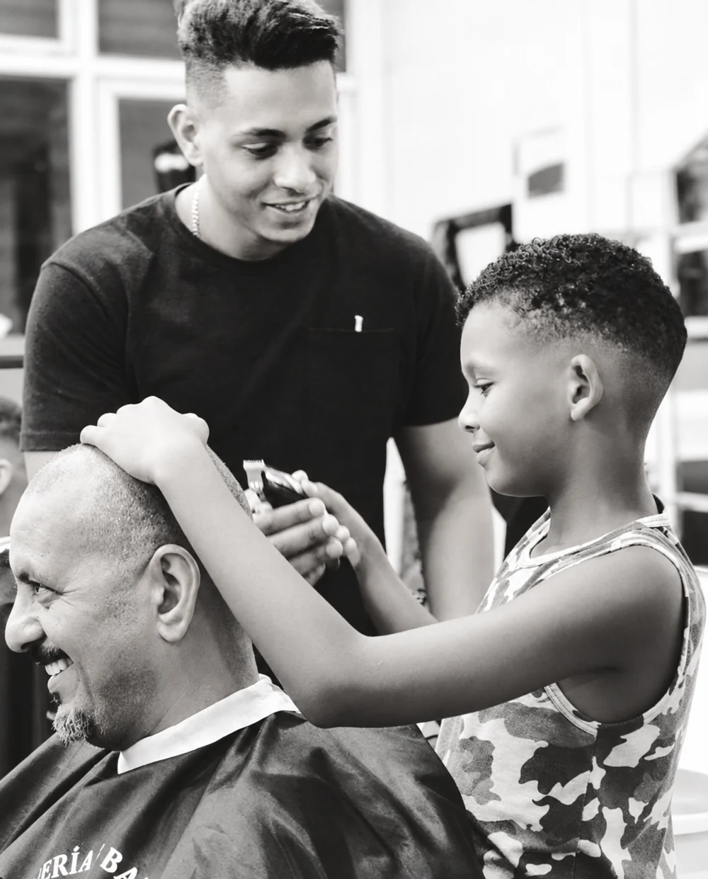 Momento familiar en la barbería; fotografía en blanco y negro restaurada digitalmente